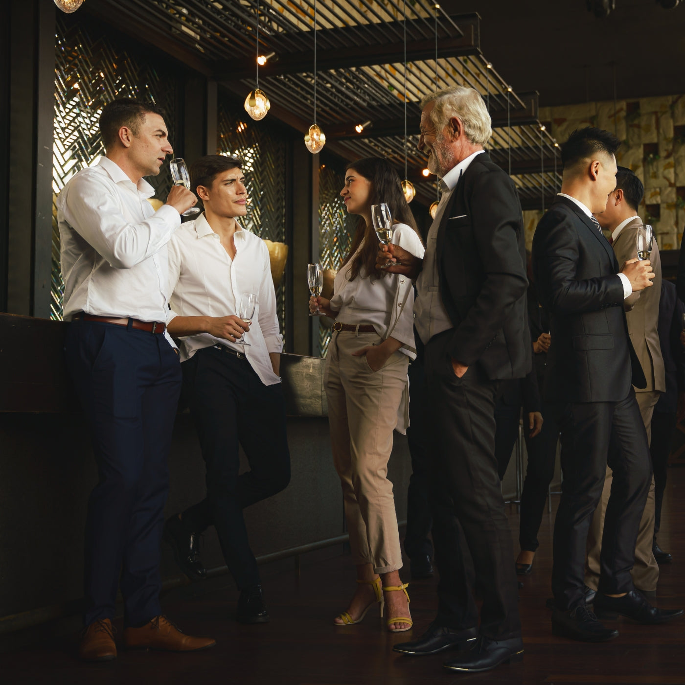Corporate businesspeople socializing and enjoying drinks together at a party in a club, celebrating a special event such as a corporate anniversary.