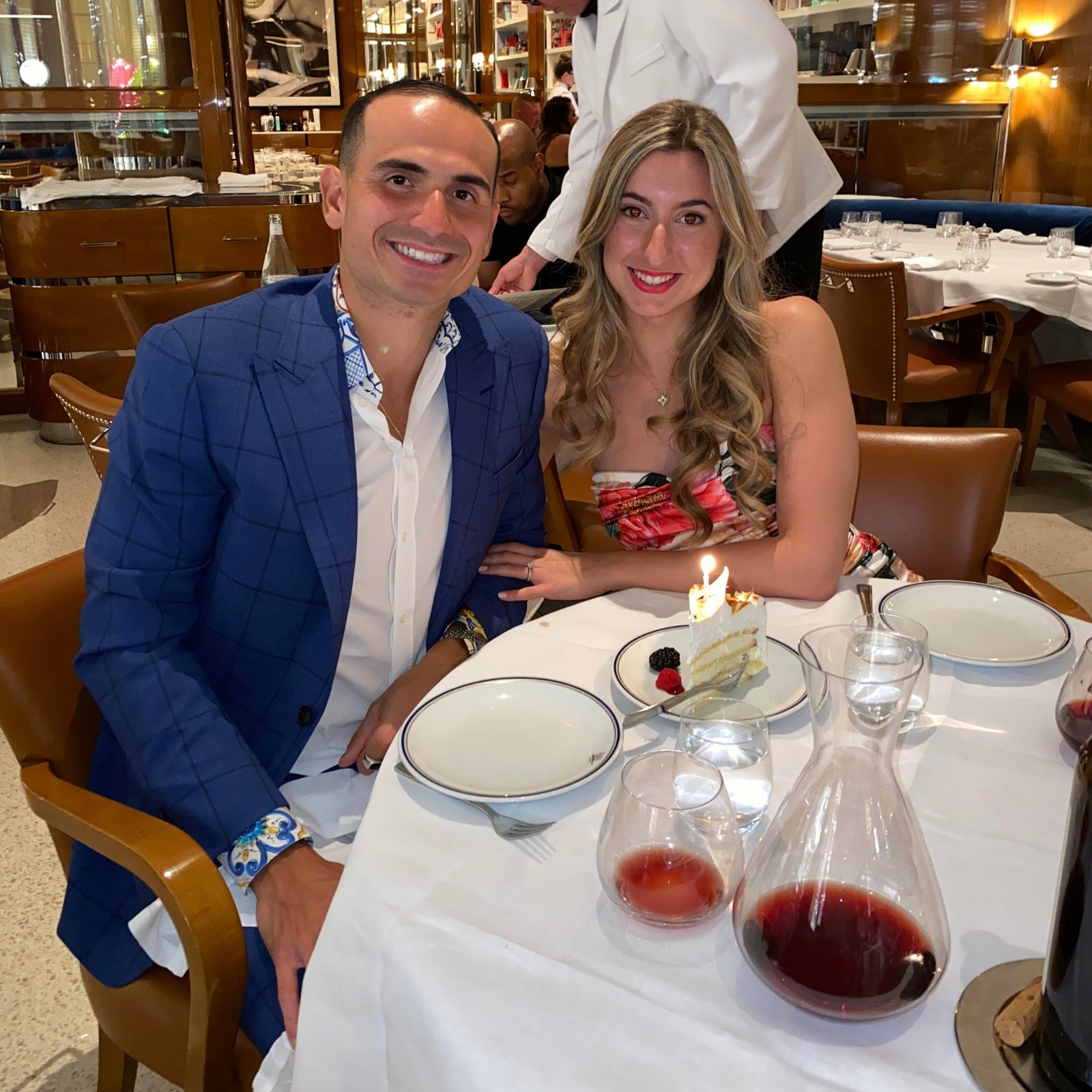 A couple celebrating with wine and dessert at a fine dining restaurant.
